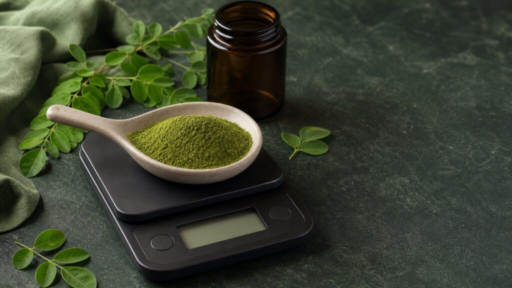 Poudre de moringa mesurée sur une balance pour respecter la quantité par jour